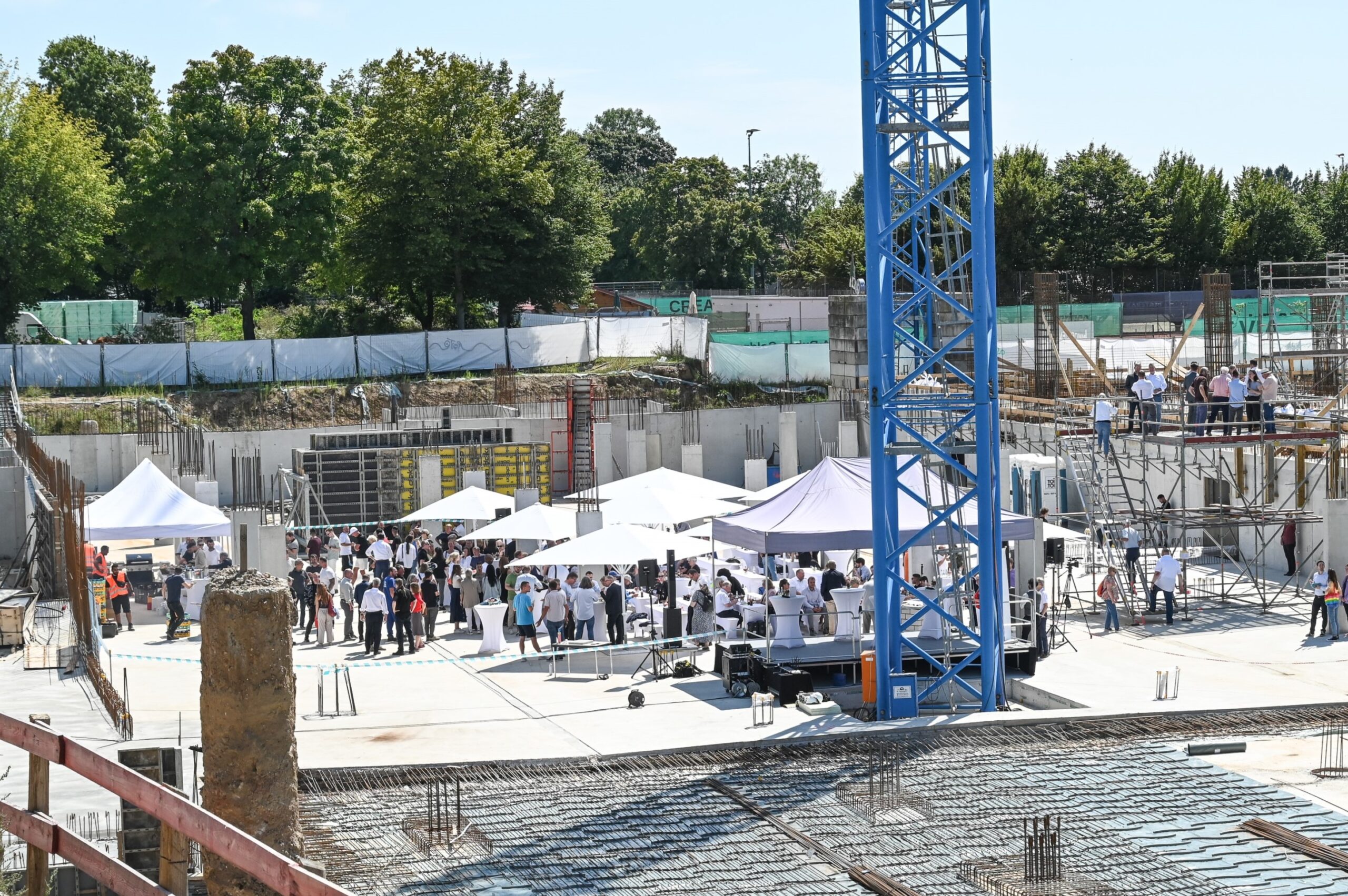 Zu sehen sind die Baustelle und die Gäste aus der Ferne.